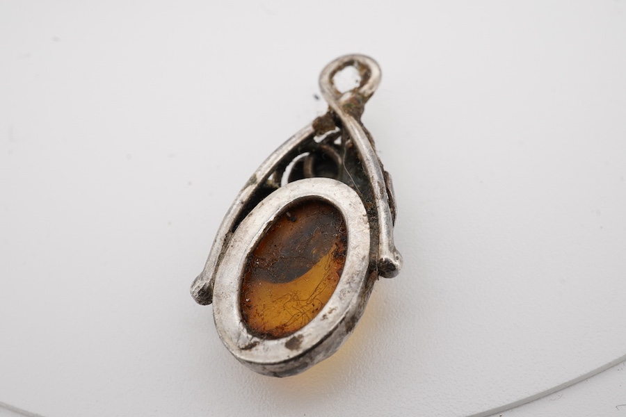 An Indian white metal fringe necklace, 37.5cm, a large antique white metal mounted amber pendant(a.f.), one other later smaller amber pendant and a filigree brooch. Condition - poor to fair